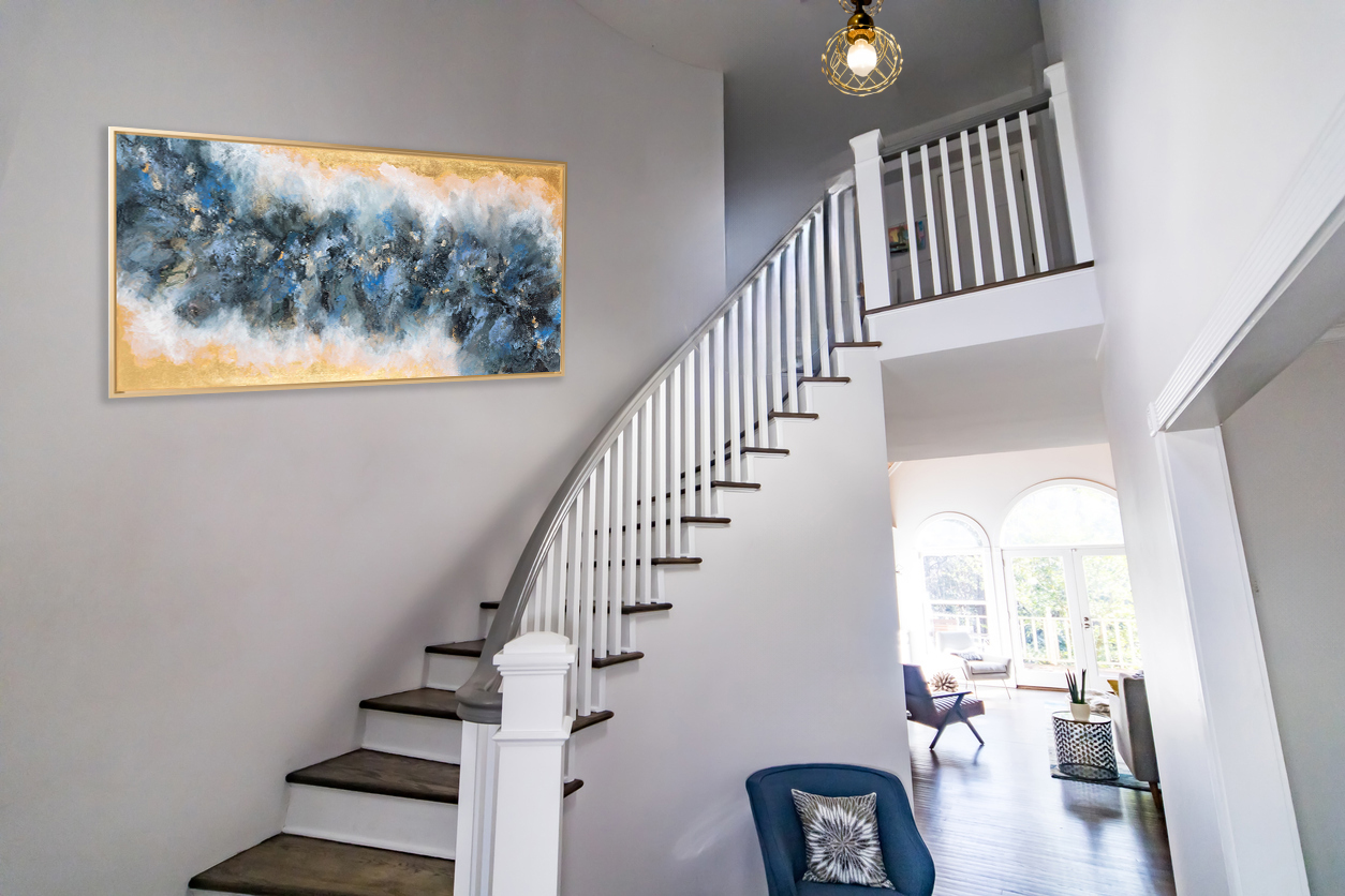 View From The Front Door Of An Open Floor Hallway Entrance With A Winding Wood Staircase And Balcony, A Teal Accent Chair And A Globe Chandelier Lighting Ficture